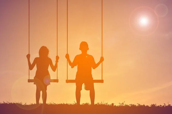Siluet çocuklar günbatımı üzerinde oyun — Stok fotoğraf