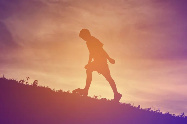 Silhouette un ragazzo che corre al tramonto — Foto Stock