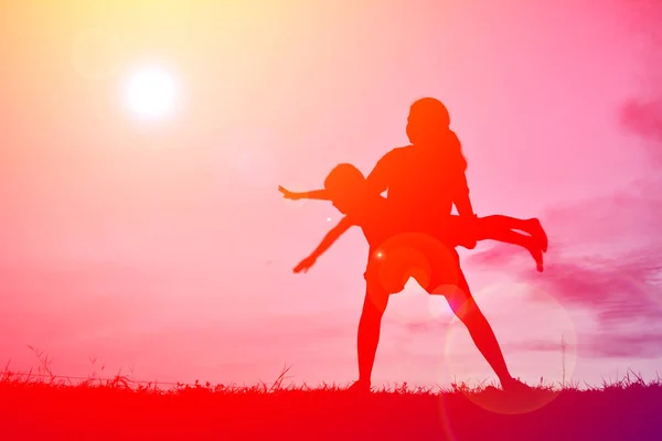 Silhouettes mère et petit fils jouant au coucher du soleil — Photo