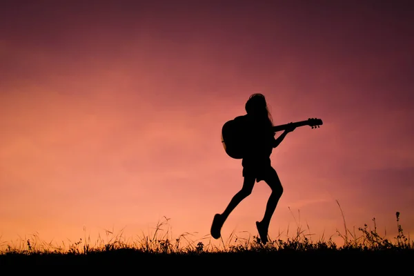 Silhouette glad flicka spela gitarr solnedgång, glad samtidigt sky — Stockfoto