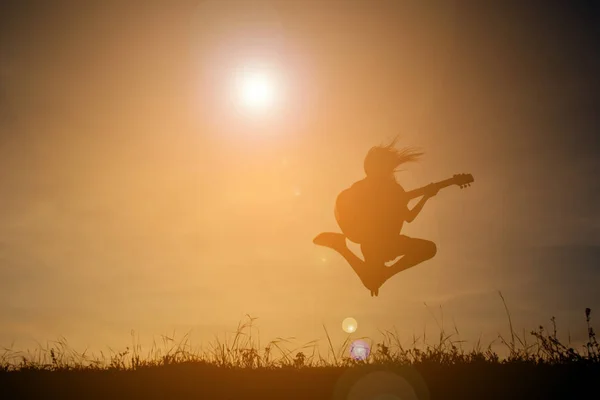 Siluet mutlu kız gökyüzü günbatımı, mutlu zaman gitar çalmak — Stok fotoğraf