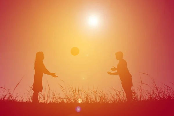 Silhouette enfants jouant au football sur le ciel coucher de soleil . — Photo