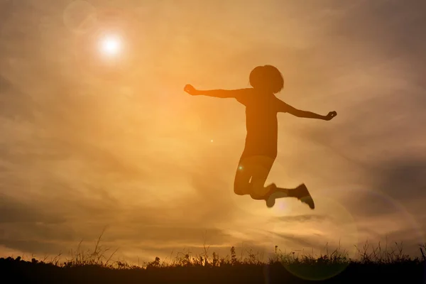 空の夕焼けで遊んで幸せな女性のシルエット — ストック写真