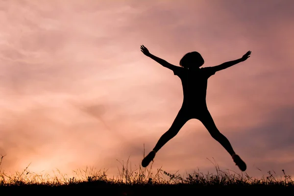 Silhouette glücklicher Frauen beim Spielen und Springen am Sonnenuntergang — Stockfoto