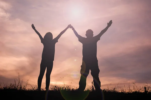 Силуетні жінки і чоловік відкрита рука на заході сонця неба, колір вінтажного тону — стокове фото