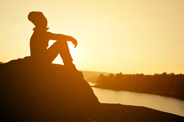 Silhouette di donne felici sulla roccia vicino al fiume — Foto Stock