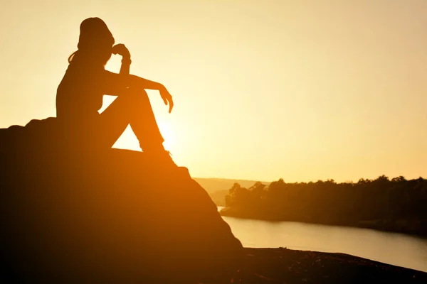 Silhouette di donne felici sulla roccia vicino al fiume — Foto Stock