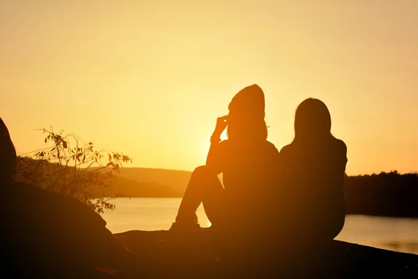 Silhouette de femmes heureuses sur le rocher près de la rivière — Photo