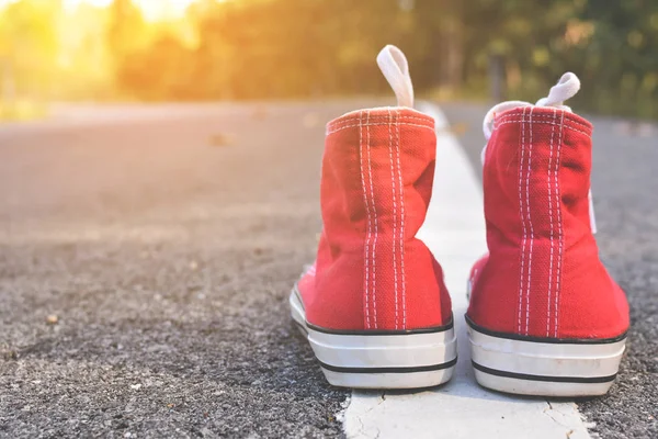 Zapatillas rojas en el fondo de la carretera — Foto de Stock