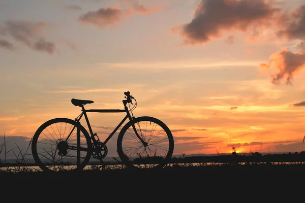 Bicicleta de silhueta perto do rio — Fotografia de Stock