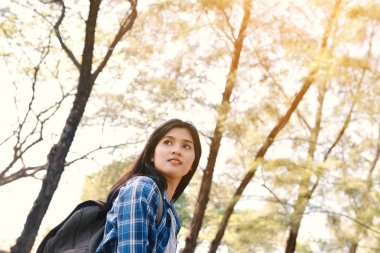 Park ve orman arka plan, Relax zaman mutlu Asyalı kız sırt çantası