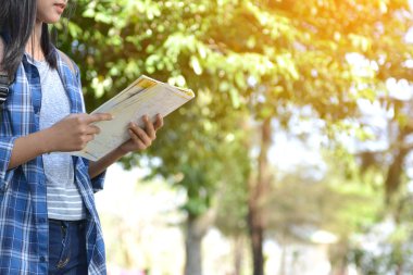 Park ve orman arka planda mutlu Asyalı kız sırt çantası