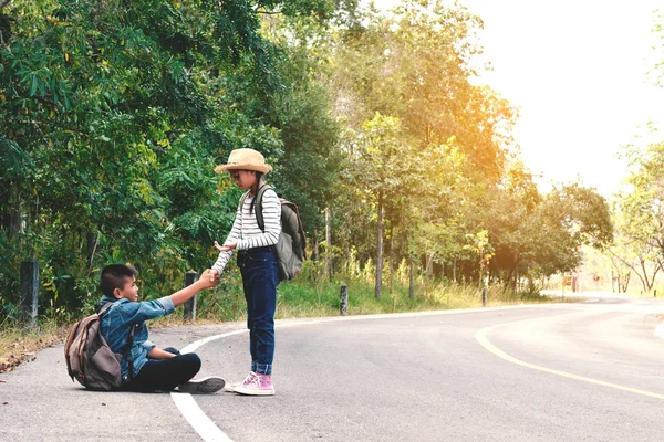 A közúti és erdő háttérben boldog ázsiai gyermekek hátizsák — Stock Fotó