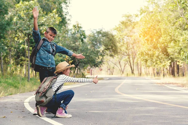 Happy Asian children backpack in the road and forest background — Stock Photo, Image