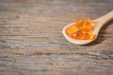 Balık yağı kaşık ahşap arka plan üzerinde