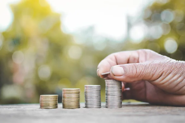 Hand holding coin on old wood tree bokeh background — Stock Photo, Image