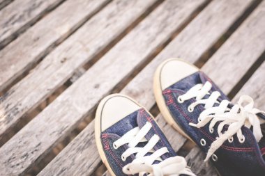 Eski ahşap arka plan ve kopya alanı üzerinde kot pantolon spor ayakkabı