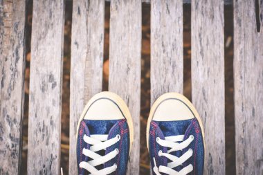 Eski ahşap arka plan ve kopya alanı üzerinde kot pantolon spor ayakkabı