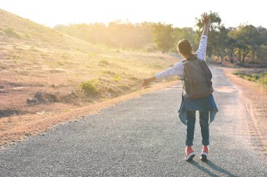 Doğa arka planda mutlu Asyalı kız sırt çantası