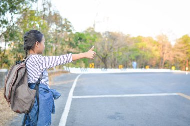 Doğa arka planda mutlu Asyalı kız sırt çantası, h zamanında Relax