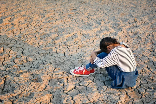 Triste una chica sentada en tierra seca .concept esperanza y sequía — Foto de Stock