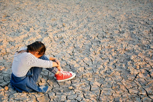 Triste una ragazza seduta su terreno asciutto .concept speranza e siccità — Foto Stock