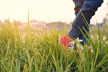 Ayakları kırmızı spor ayakkabı bir kız doğada ve tatil zamanında rahatla. sel