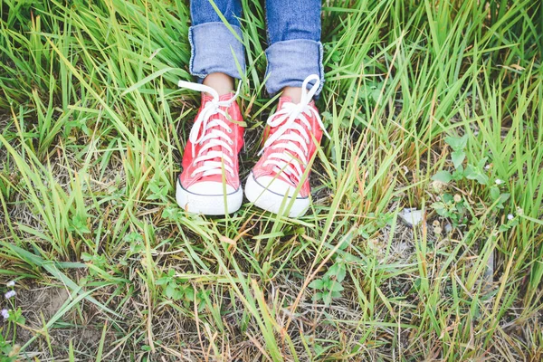 Feet red sneaker a girl in nature and relax time on holiday. sel — Stock Photo, Image
