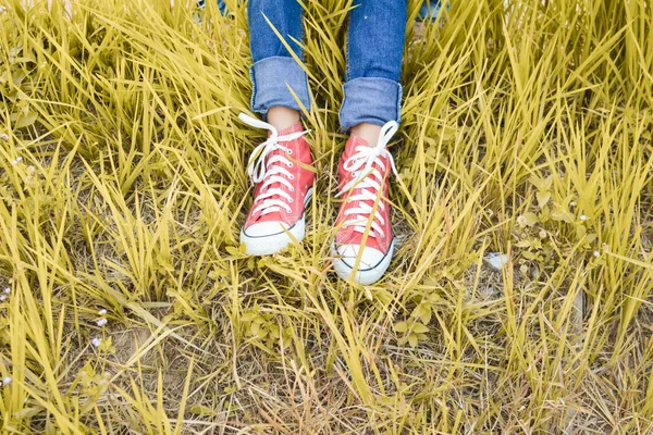 Pies zapatilla de deporte roja una chica en la naturaleza y relajarse tiempo de vacaciones. SEL — Foto de Stock
