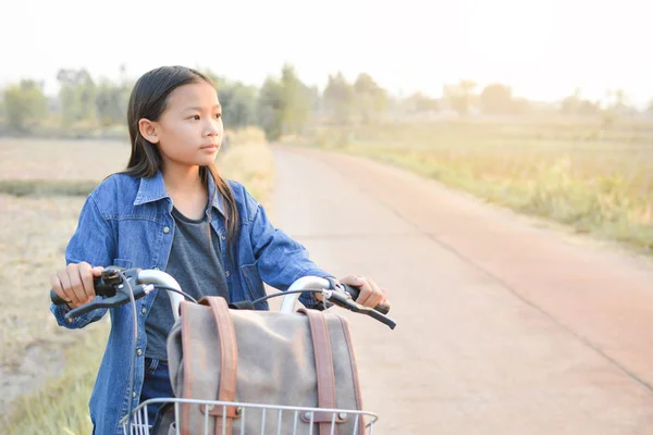 Gelukkig meisje met fiets op grasveld, selectieve en zachte focus — Stockfoto
