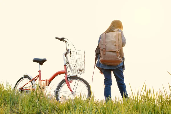 Счастливая девушка с велосипедом на травяном поле, избирательный и мягкий фокус — стоковое фото