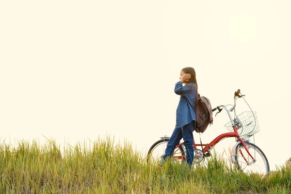 Chica feliz con bicicleta en el campo de hierba, enfoque selectivo y suave —  Fotos de Stock
