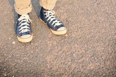 Hipster ayak bir adam ve kot pantolon spor ayakkabı doğada tatil zamanında rahatlamaya