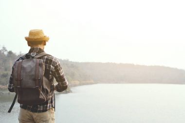 Doğa arka planda mutlu Asya hipster adam sırt çantası