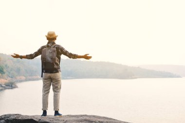 Doğa arka planda mutlu Asya hipster adam sırt çantası