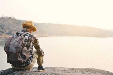 Doğa arka planda mutlu Asya hipster adam sırt çantası