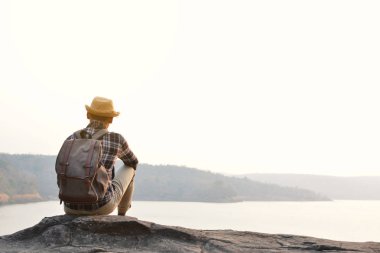 Doğa arka planda mutlu Asya hipster adam sırt çantası