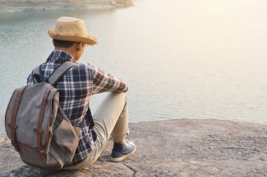 Doğa arka planda mutlu Asya hipster adam sırt çantası