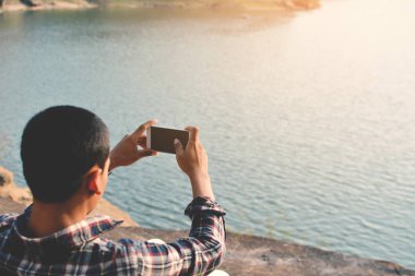 Doğa arka planda mutlu Asya hipster adam sırt çantası