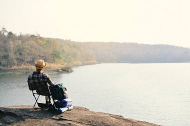 Doğa arka planda mutlu Asya hipster adam sırt çantası