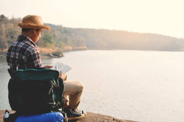 Mutlu Asya hipster adam doğa arka planda bir kitap okuma