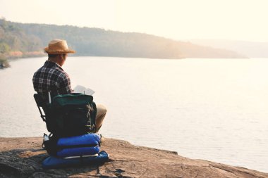 Doğa arka planda mutlu Asya hipster adam sırt çantası