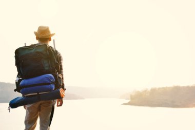 Doğa arka planda mutlu Asya hipster adam sırt çantası