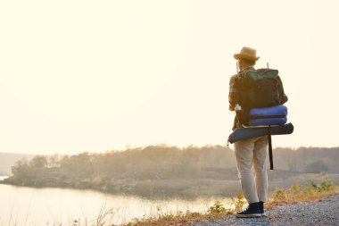 Doğa arka planda mutlu Asya hipster adam sırt çantası