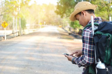 Doğa arka planda mutlu Asya hipster adam sırt çantası