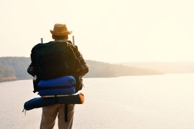 Doğa arka planda mutlu Asya hipster adam sırt çantası