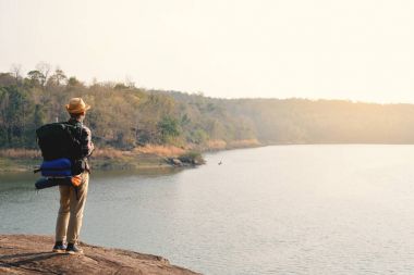 Doğa arka planda mutlu Asya hipster adam sırt çantası