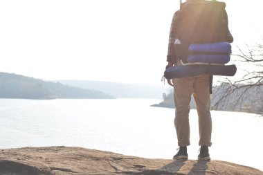 Doğa arka planda mutlu Asya hipster adam sırt çantası