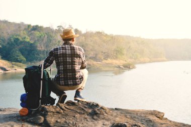 Doğa arka planda mutlu Asya hipster adam sırt çantası