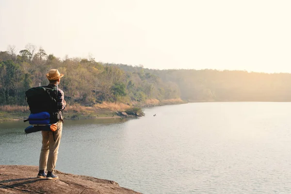 Doğa arka planda mutlu Asya hipster adam sırt çantası